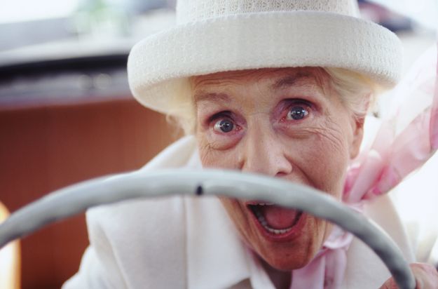 Ecstatic senior woman driving a convertible