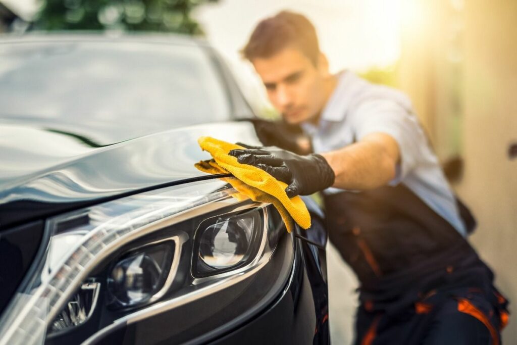 Uomo lucida l'auto a mano