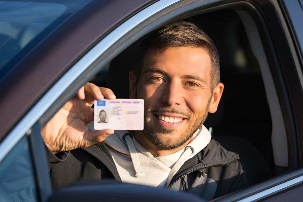 uomo in auto con patente