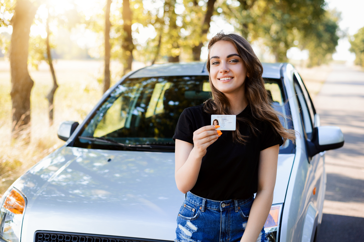 Una ragazza mostra la propria patente