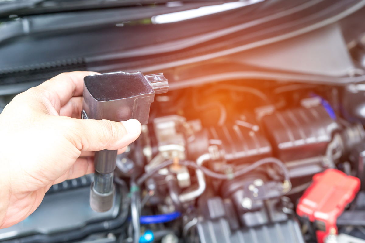 Uomo monitora e sostituisce bobina di accensione dell'auto