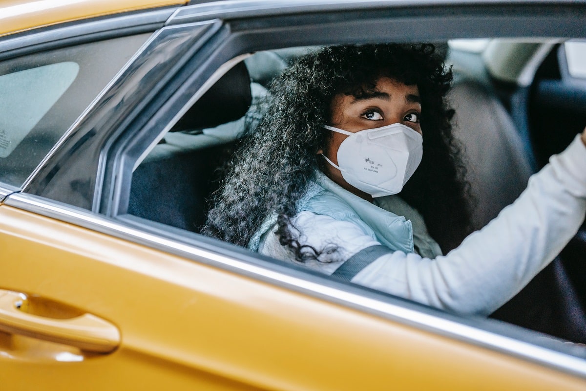 ragazza con mascherina in automobile