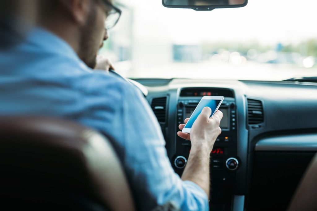 Un uomo al cellulare in auto