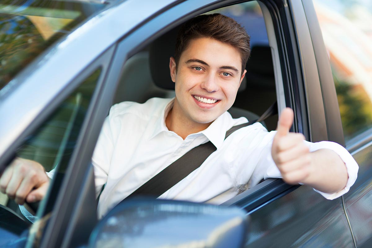 Ragazzo giovane che ha preso da poco la patente al volante di un'auto