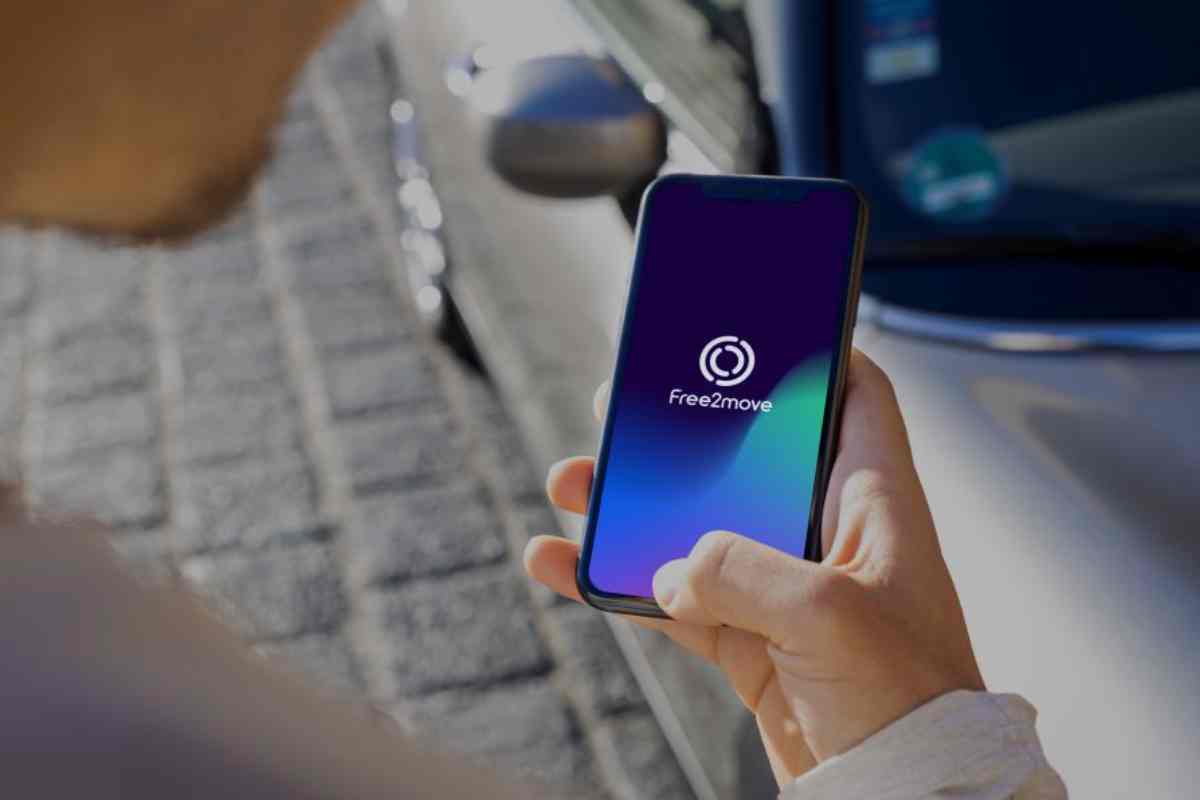 Persona che utilizza l'app Free2Move sul proprio smartphone